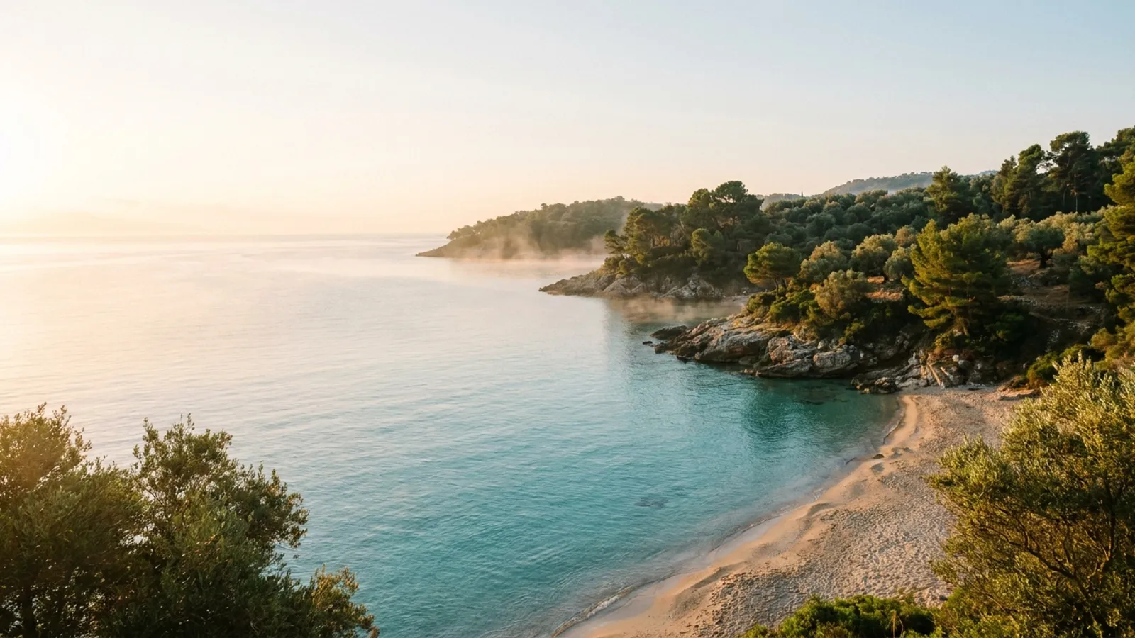 Coastal landscape with gentle waves and a sunrise over the Mediterranean Sea, evoking calm and natural beauty.